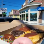Assorted donuts in a bakery box outside L&M Bakery in Delran, New Jersey on a sunny day.