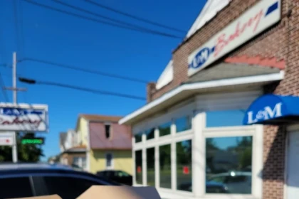 Assorted donuts in a bakery box outside L&M Bakery in Delran, New Jersey on a sunny day.