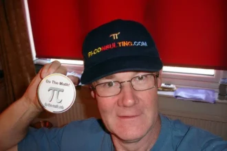 Charlie wearing Pi Market Research hat holding “Do the Math” Pi badge.