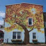 Colorful mural on building wall in downtown Mount Holly NJ featuring a tree design and public art streetscape