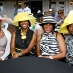 Women enjoying an outdoor brunch with mom wearing hats on Mother’s Day