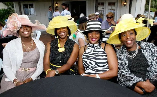 Women enjoying an outdoor brunch with mom wearing hats on Mother’s Day