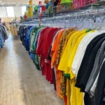 Clothing rack filled with colorful shirts inside a local thrift store in Burlington County New Jersey