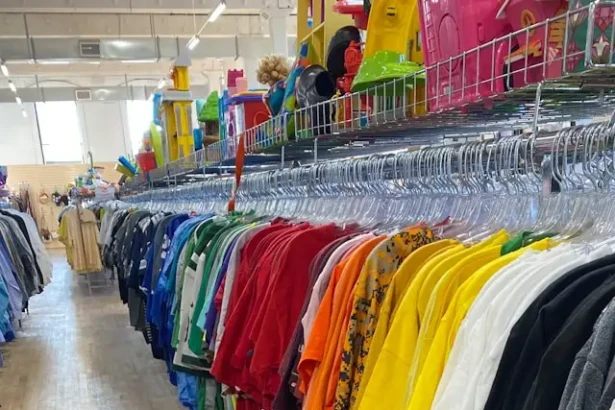 Clothing rack filled with colorful shirts inside a local thrift store in Burlington County New Jersey