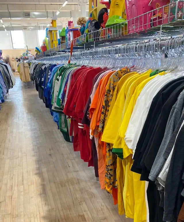 Clothing rack filled with colorful shirts inside a local thrift store in Burlington County New Jersey
