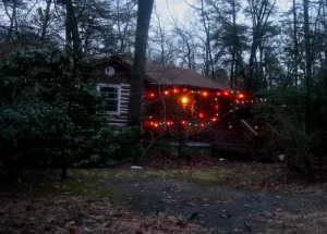 Rustic cabin-style home decorated with lights in the wooded Medford Lakes Colony area