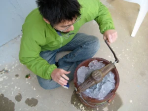 Sit With It: The Backyard Was Our Classroom 4 Young boy hand cranking old-fashioned Ice cream maker.