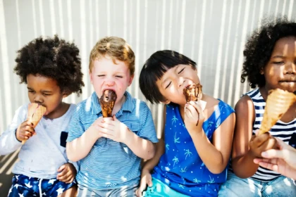 Children eating ice cream cones on a sunny day.